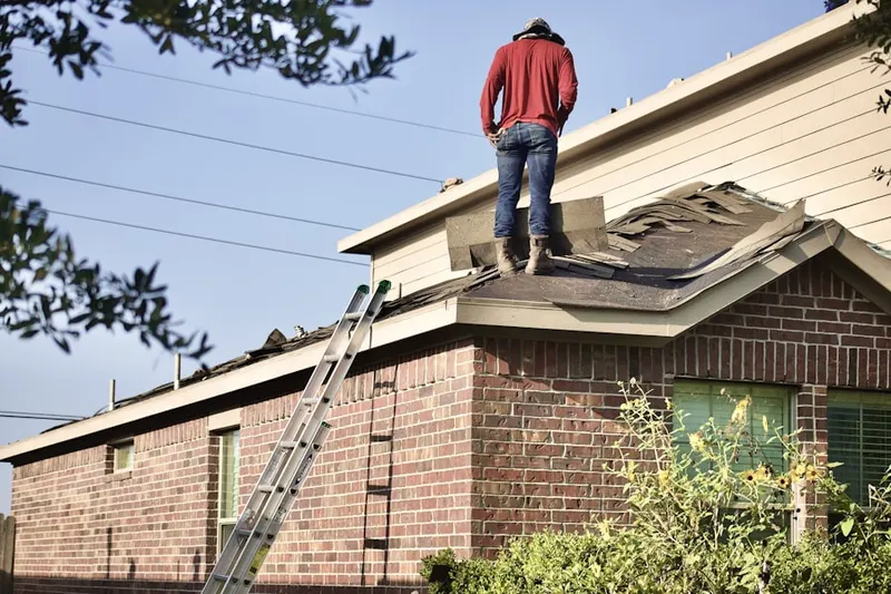 Professional roofer working on a residential roof in Victor